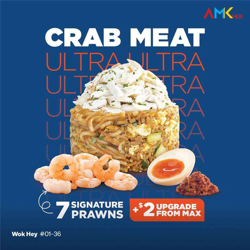 A vibrant bowl of Laksa Fried Rice or Noodles from WOK HEY, garnished with crab and egg.